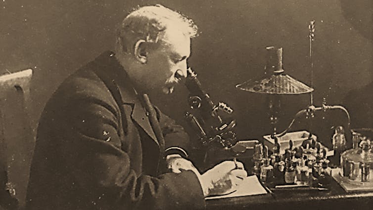 Hector Lebrun penché sur un microscope