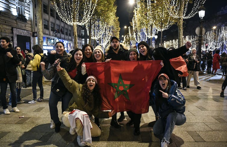 Des supporters de l’équipe marocaine célèbrent la victoire contre le Portugal sur les Champs Elysées à Paris, quelques jours avant le match qui opposera France et Maroc le 14 décembre