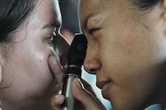un médecin ausculte les yeux d’un patient