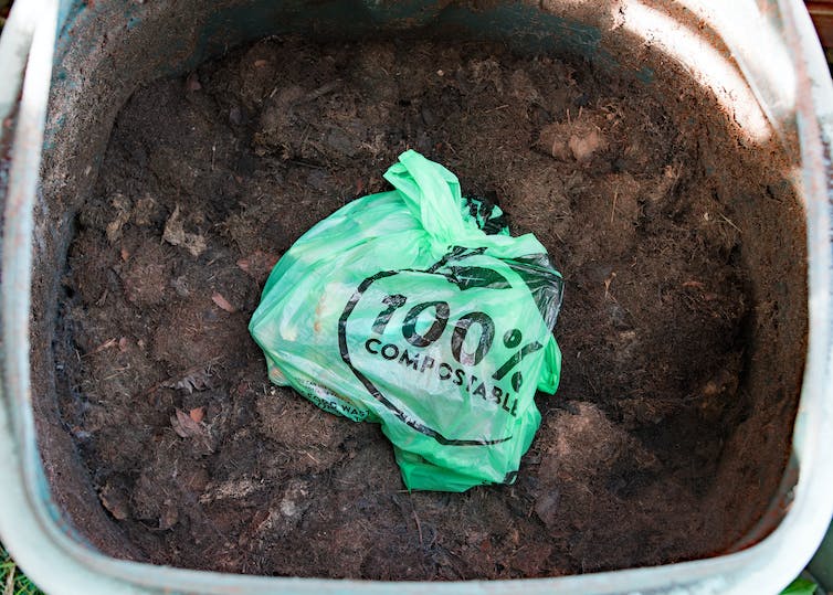 sac plastique vert dans la terre