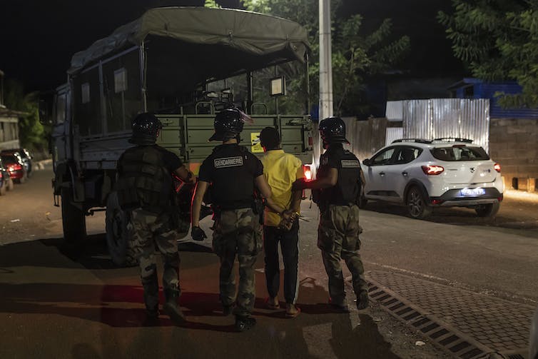Des gendarmes français arrêtent un homme lors d’une opération de police à Dzoumogne, sur l’île de Mayotte, le 1ᵉʳ mai 2023