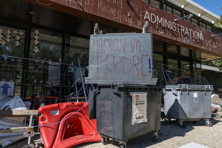 Le 4 avril 2023, l’entrée d’un bâtiment de l’université Paul Valery à Montpellier bloquée par des tables, des chaises et des poubelles pour protester contre la réforme des retraites, un slogan « Macron va perdre » est inscrit