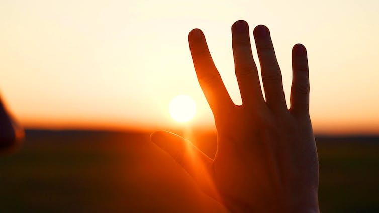 main qui protège du soleil
