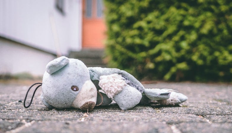 ourson en peluche abîmé sur la rue