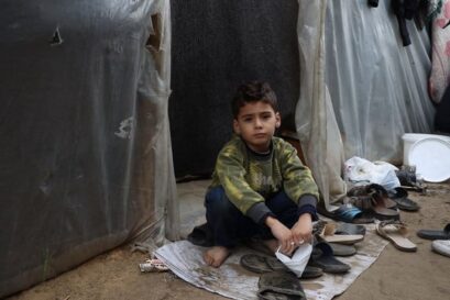 Un enfant se tient à côté de tentes dans un centre d'hébergement situé dans l'enceinte de l'université Al-Aqsa, dans la bande de Gaza.