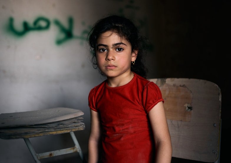 Tabarak, 6 ans, Irak. Tabarak vit dans le quartier ouest déchiré par la guerre, dans la vieille ville de Mossoul. Elle est assise dans une salle de classe vide de l