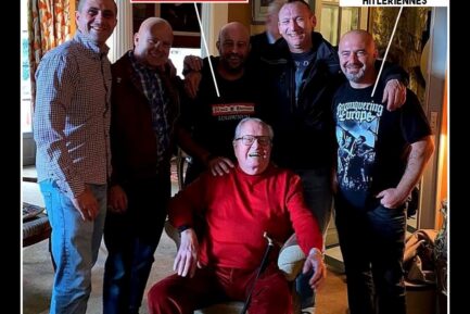 Des nazis prennent la pose avec Jean-Marie Le Pen, tout sourire dans son fauteuil.