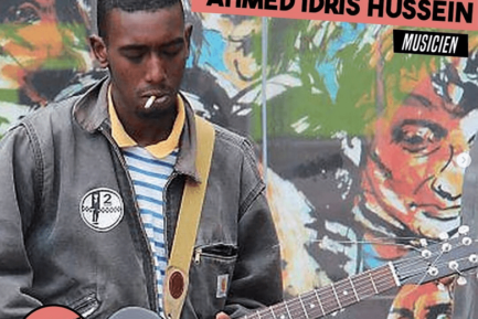 Ahmed Idris Hussein jouant de la guitare dans la rue.