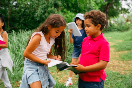 Des enfants entrain de travailler dans la nature. Les jeunes passent trop de temps devant les écrans.