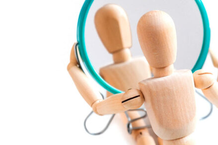 Bonhomme articulé en bois regardant son reflet dans un miroir © GIOIA Photo / Shutterstock.com