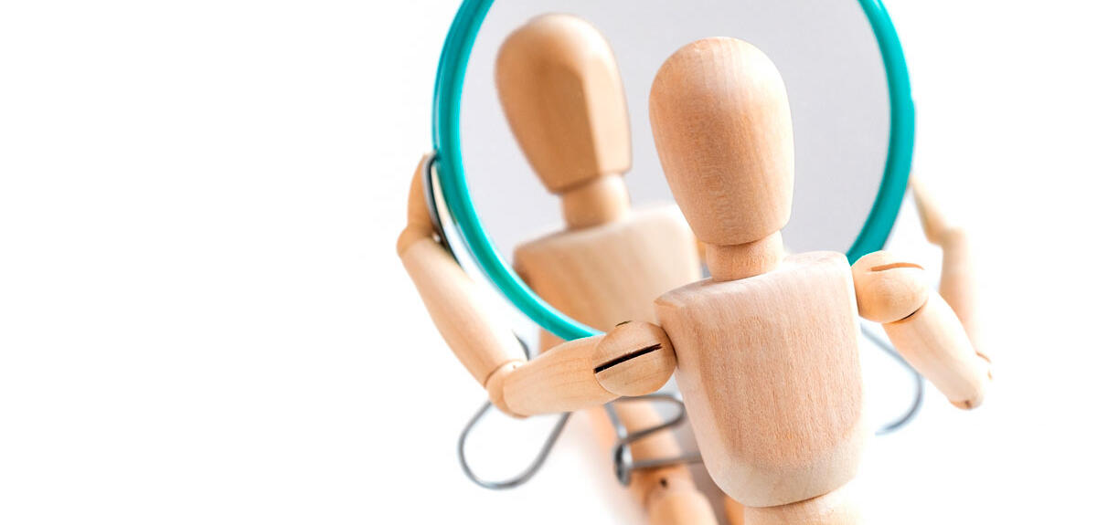 Bonhomme articulé en bois regardant son reflet dans un miroir © GIOIA Photo / Shutterstock.com