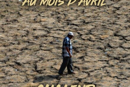 Un homme en chemise marche sur une terre dessechée par un record de chaleur.
