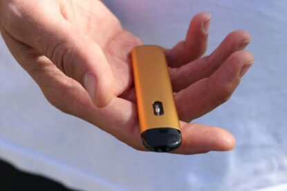 Cigarette électronique jetable jaune dans une main.