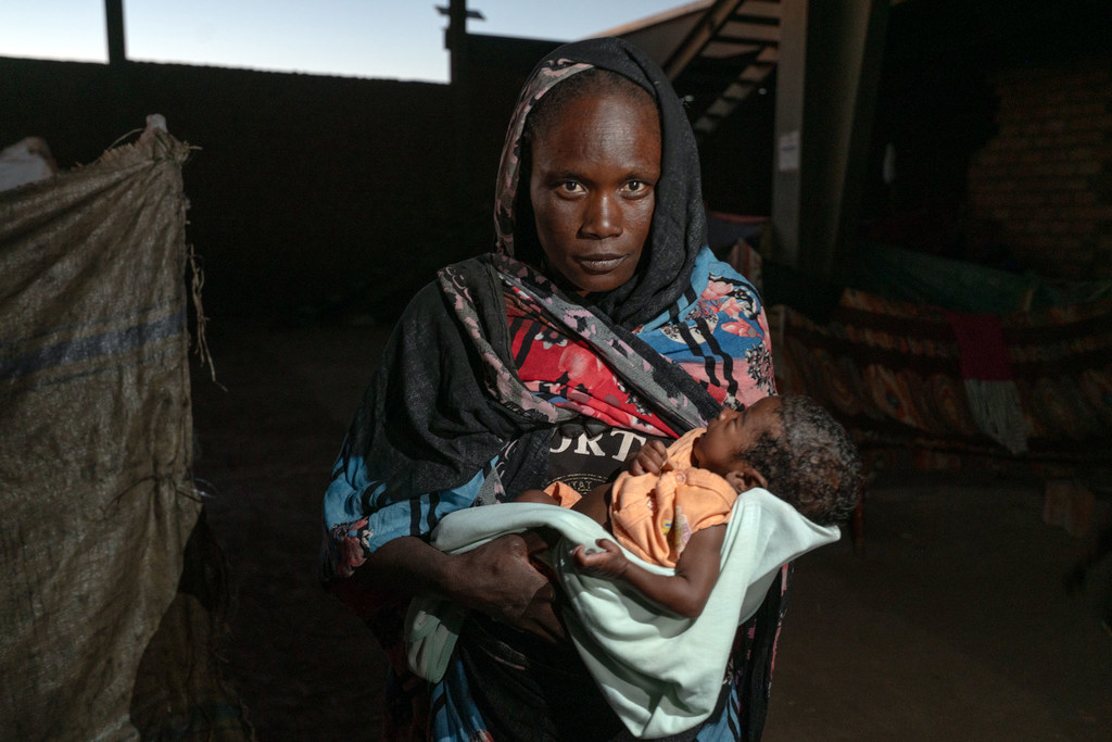 Une femme tient son enfant mal nourri dans ses bras dans un site de déplacés à Gedaref, au Soudan.