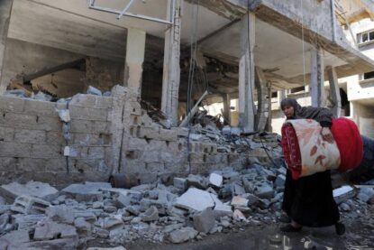 Une résidente palestinienne marche derrière un bâtiment détruit par les frappes aériennes israéliennes à Gaza. Les violences basées sur le genre touchent les femmes et les filles de manière disproportionnée.
