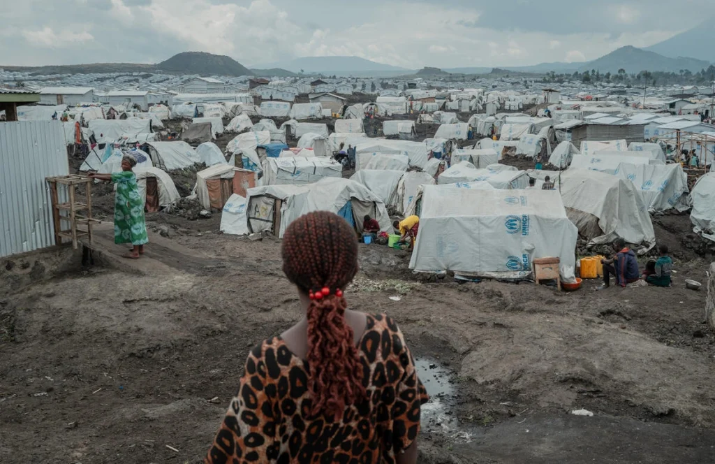 Une femme déplacée à l'intérieur de son propre pays regarde le site de déplacement de Lushagala dans la province du Nord-Kivu, en République démocratique du Congo.