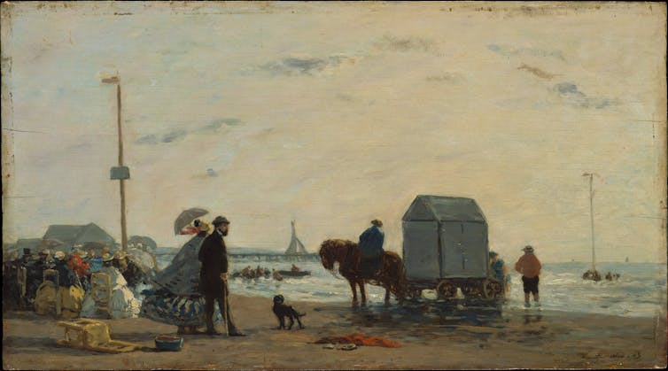 Couple vêtu de vêtements du XIXᵉ siècle marchant sur une plage avec un cheval et une charrette