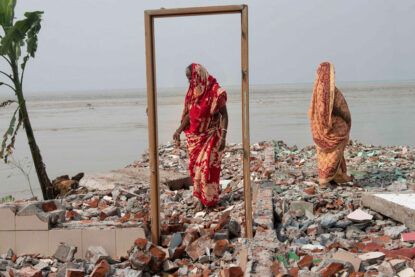 Deux femmes se tiennent sur les restes d’une maison détruite par l’érosion en bordure du fleuve Padma, Bangladesh