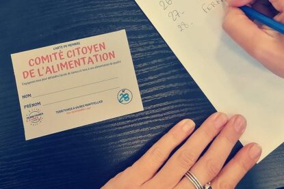 une main posée à côté d'une carte de membre du comité citoyen de l'alimentation.
