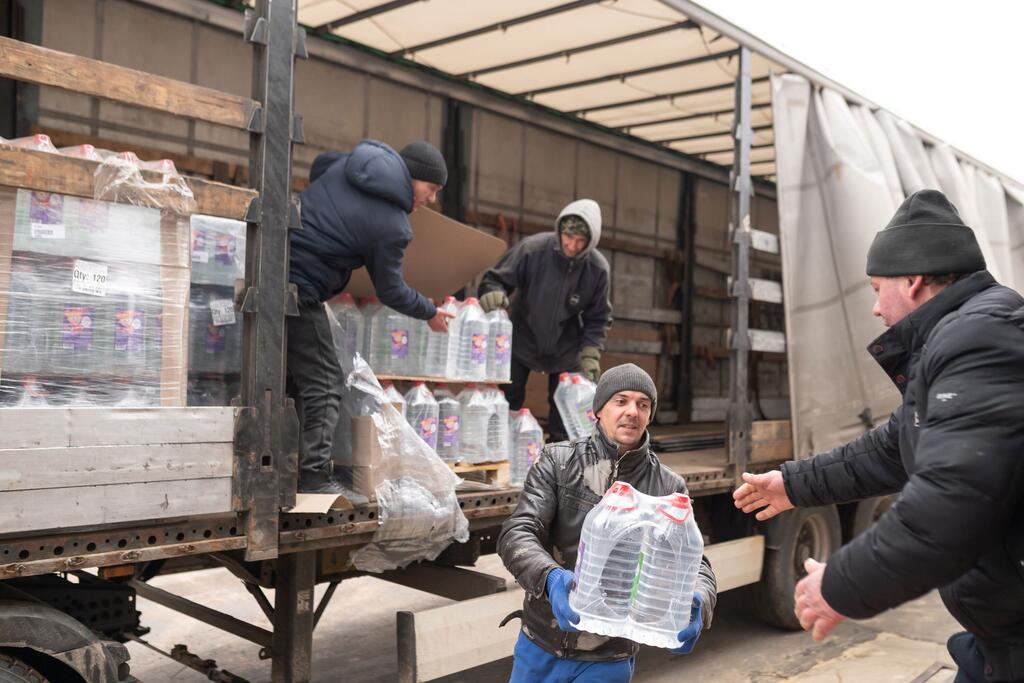 Des hommes déchargent de grosses bouteilles d'eau potable d'un camion dans le cadre d'un effort de secours de l'UNICEF à Rozdilna, en Ukraine, à la suite de graves inondations qui ont contaminé les sources d'eau locales.