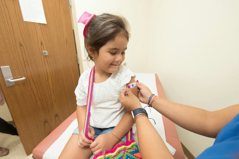 une fillette se fait vacciner