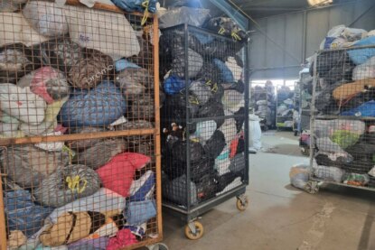 Containers remplis de vêtements dans des sacs poubelles